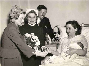 Photo:The Duchess of Gloucester, accompanied by the Minister of Health and the Matron, present Mrs Arthur Cantwell of Spurstowe Road with an engraved silver christening cup, 2 May 1951 (Catalogue reference: SBHH-PG-44).